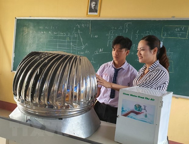 Em Trần Hữu Tỉ và cô giáo hướng dẫn Vũ Thị Thúy Hằng, giáo viên bộ môn Vật Lý nghiên cứu cải tiến mô hình máy tạo ra nước sạch từ năng lượng điện gió.