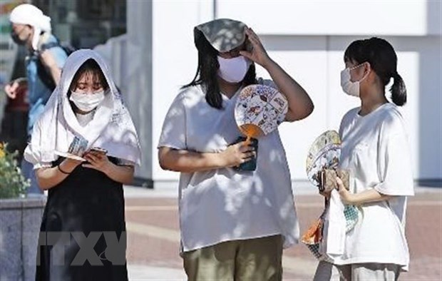 Người dân tránh nắng nóng dưới bóng cây tại Hamamatsu, tỉnh Shizuoka, miền Trung Nhật Bản.