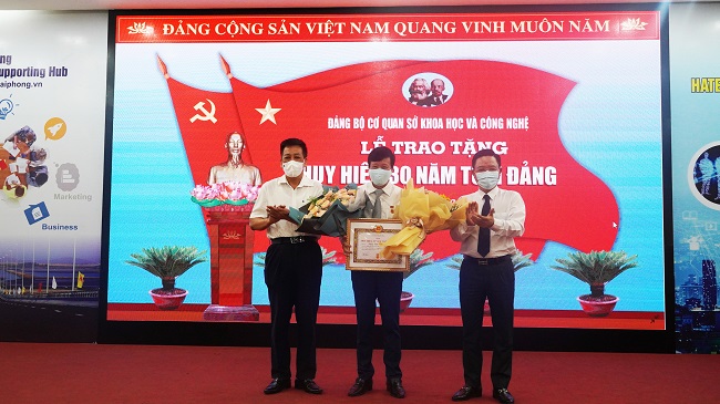 Đồng chí Phạm Xuân Thanh và đồng chí Trần Quang Tuấn trao Huy hiệu 30 năm tuổi Đảng cho đồng chí Đặng Trần Kiên.